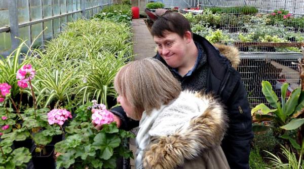 Couple with Down Syndrome smelling flowers