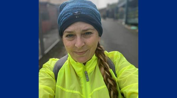 Melissa Young on one of her training days wearing a beanie hat and a high vis yellow jacket, she is smiling at the camera and is wearing her hair in one long plait.