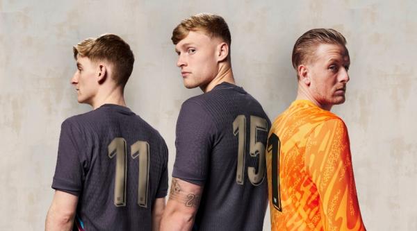 Three England players wearing football shirts without names on