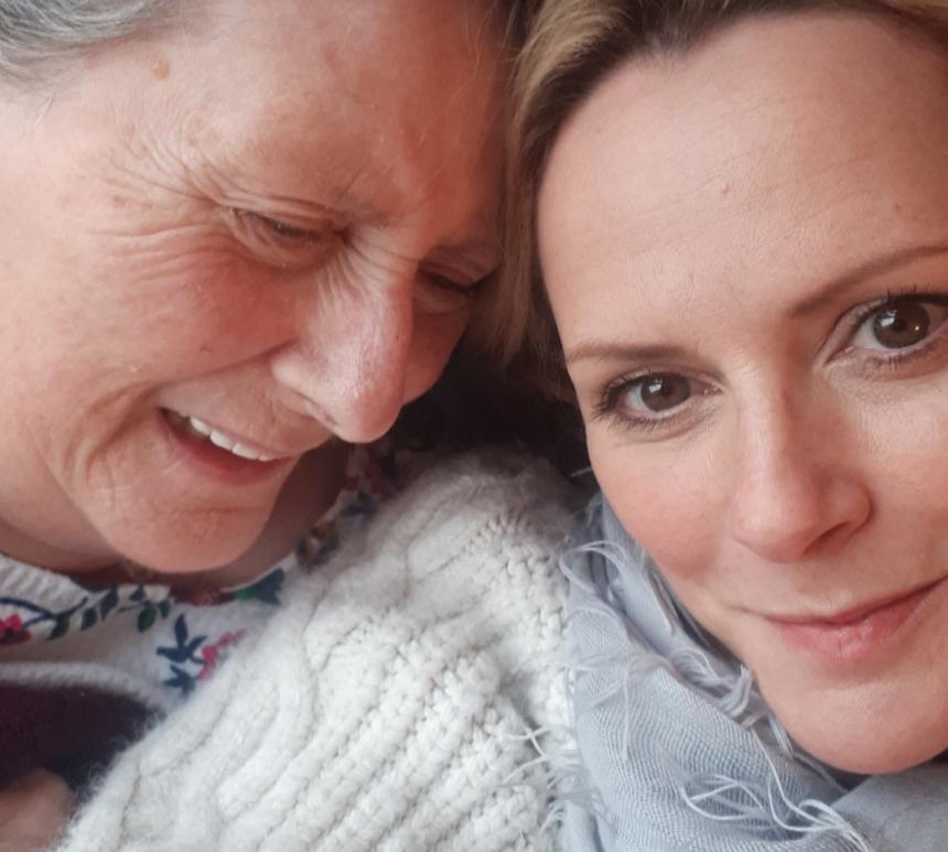 Julie and her mum, lay down and smiling while taking a selfie