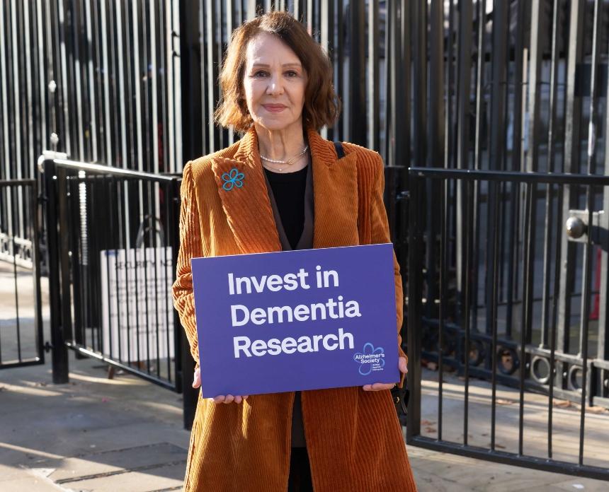 Dame Arlene Phillips holds up a sign that says 'Invest in Dementia Research' outside Downing Street