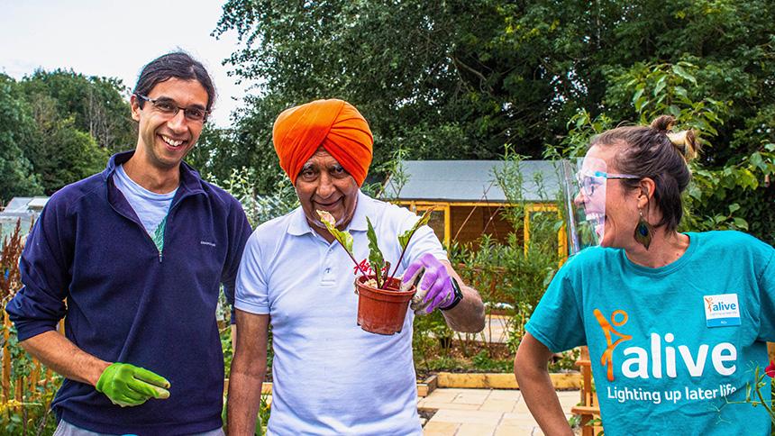 Three people enjoying gardening with Bristol charity, Alive.