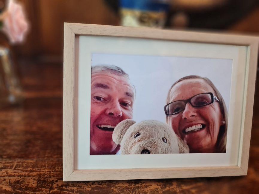 A photo frame with a picture of Bill and Jo and a teddy