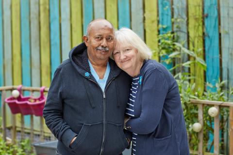 A couple in their garden lean in to each other in support