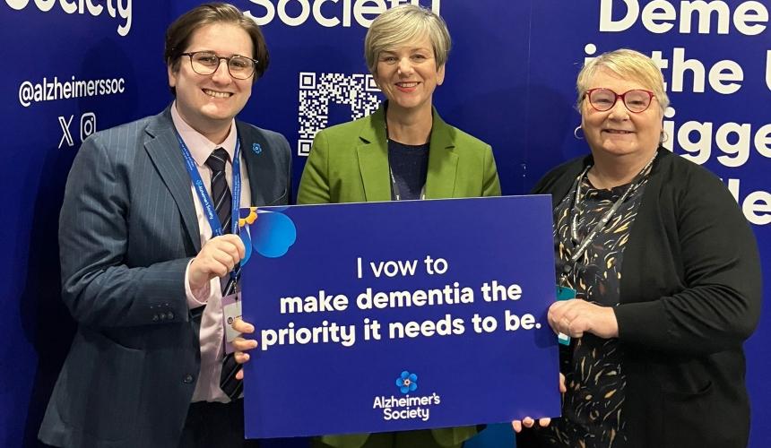 Michelle and Lewis holding a sign that says 'I vow to make dementia the priority it needs to be'