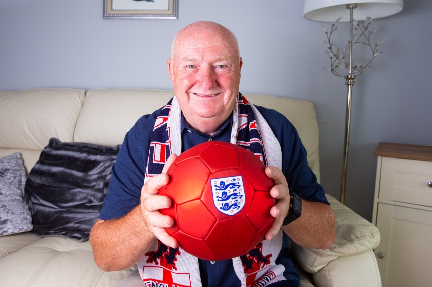 Tommy Dunne smiling, holding a red football