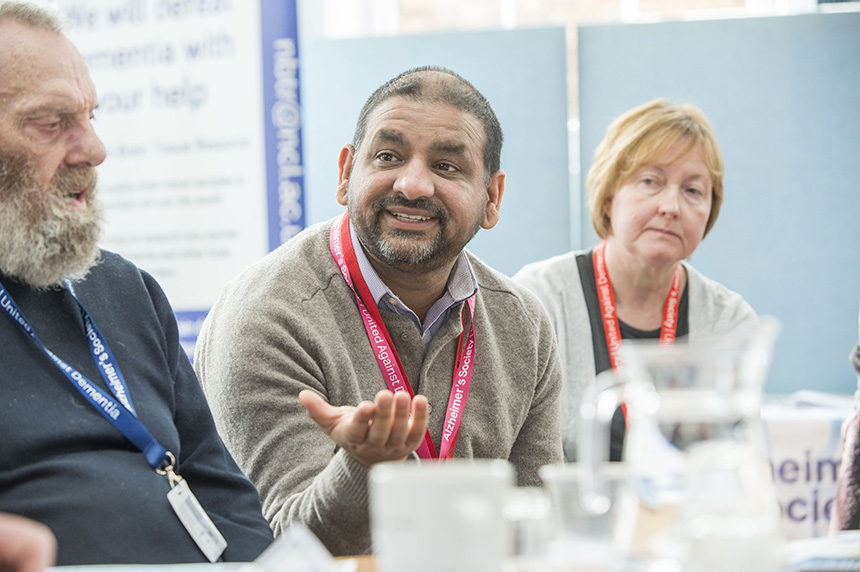 A researcher gestures across a table explaining his research