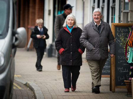 A man and woman walking down a high street