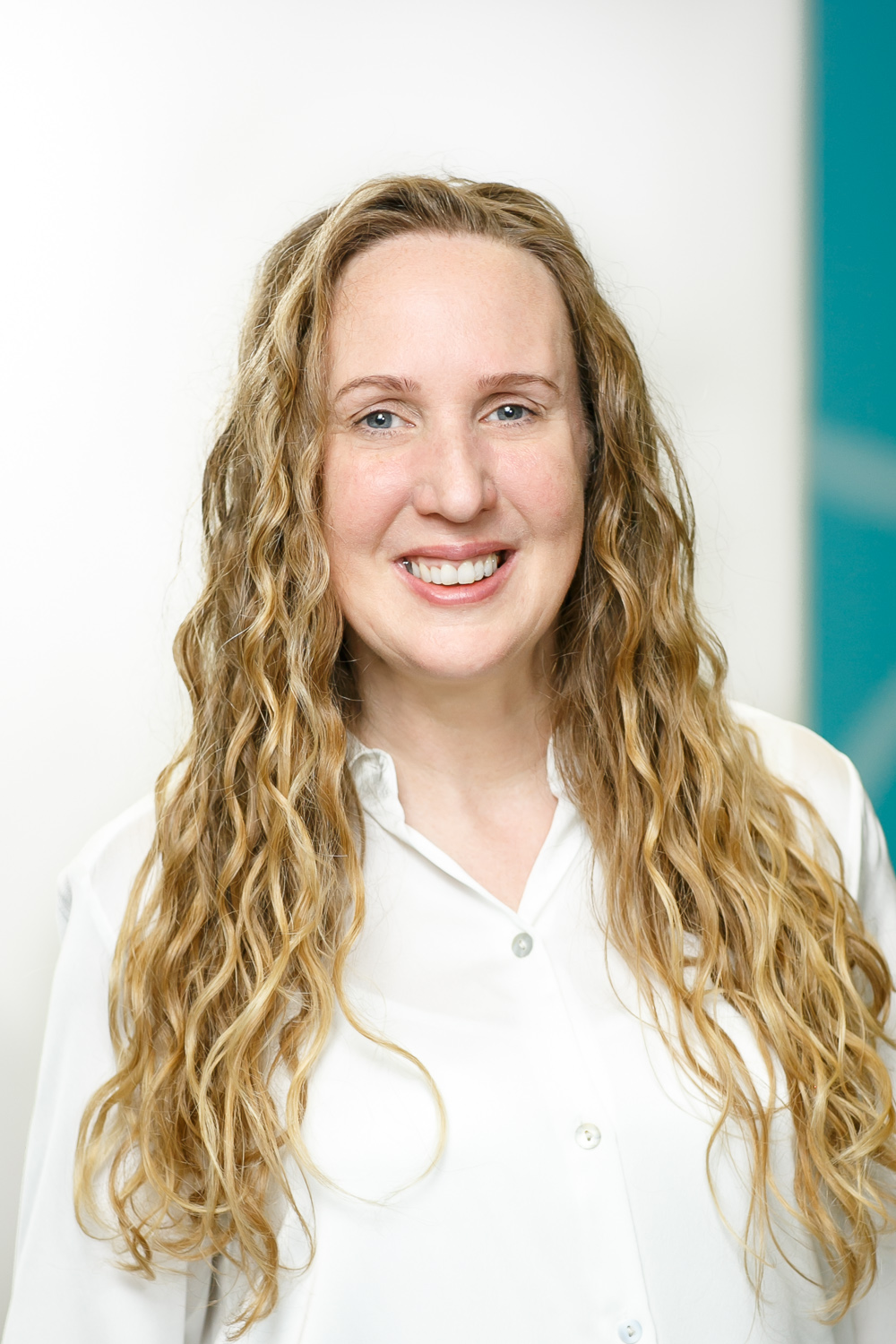 Alison Waine, wearing a white shirt, smiling