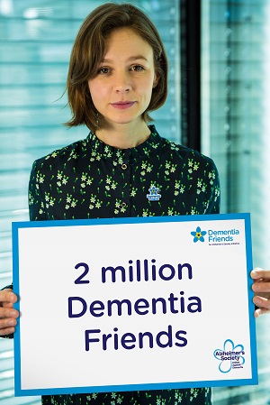 Carrey Mulligan holding a sign that says '2 million dementia friends'