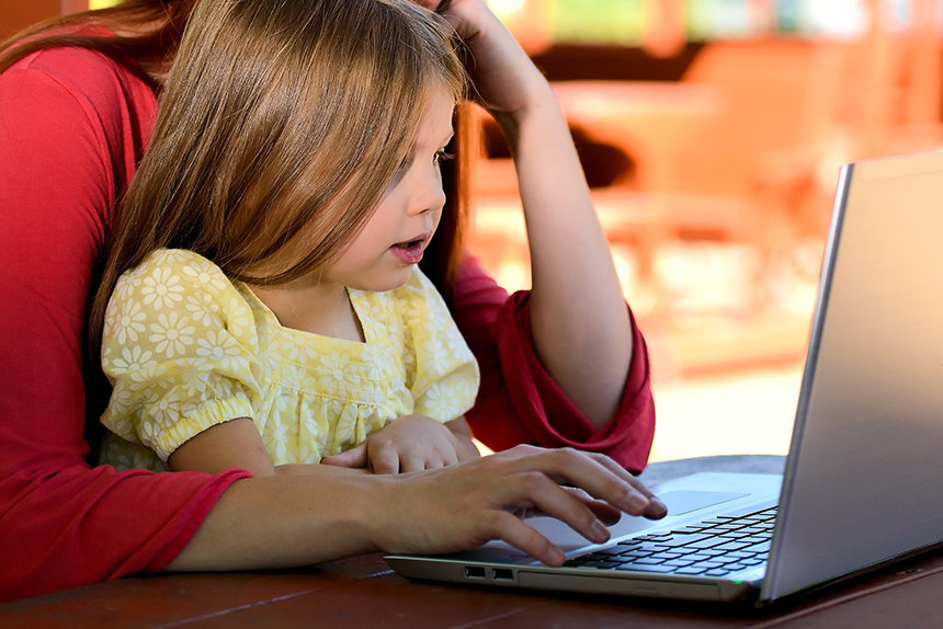 Child helping parent at a laptop