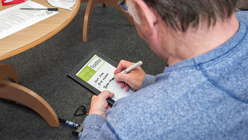 A man writing on a dry-erase board