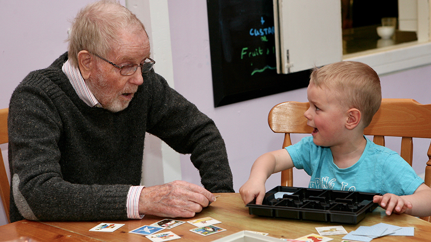 A male care home resident interacts with a young boy