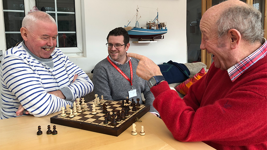 Two men (Ian and Raymond) play chess