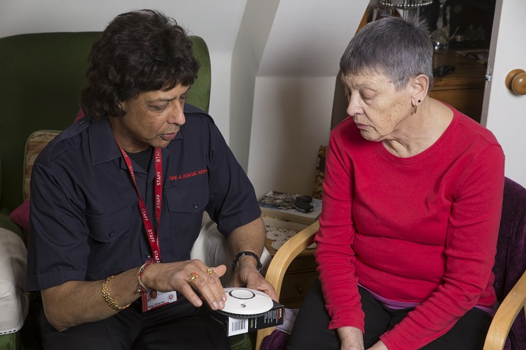 Fire services employee on a home visit to fit a fire alarm