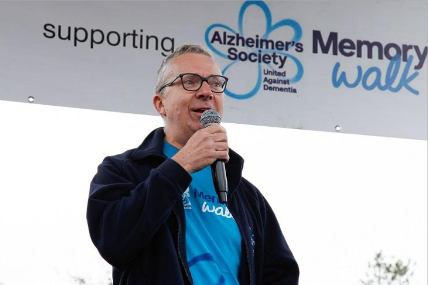 Jeremy Hughes speaking with a microphone in his hand