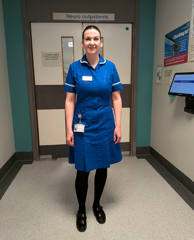 Portrait photo of a young woman wearing nurse scrubs in a hospital corridor.