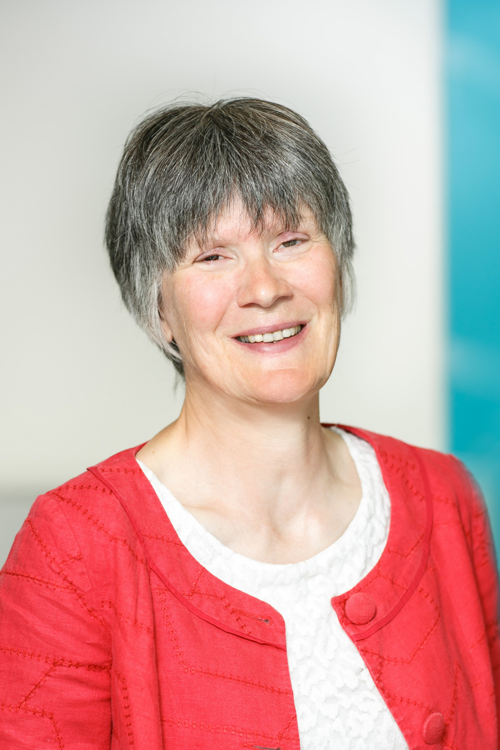 Katrina Avery, wearing a white top and red jacker, smiling