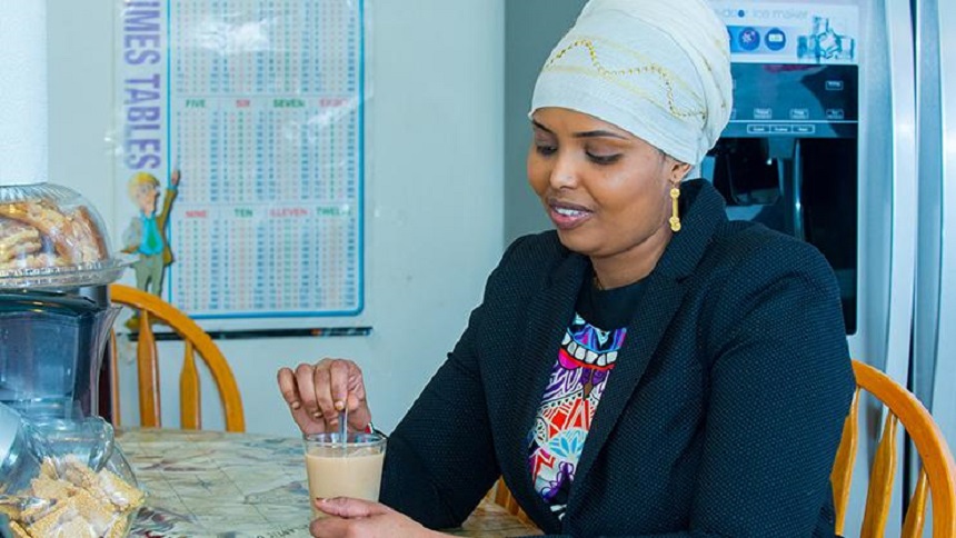 Khadra Abdi stirring tea on a table