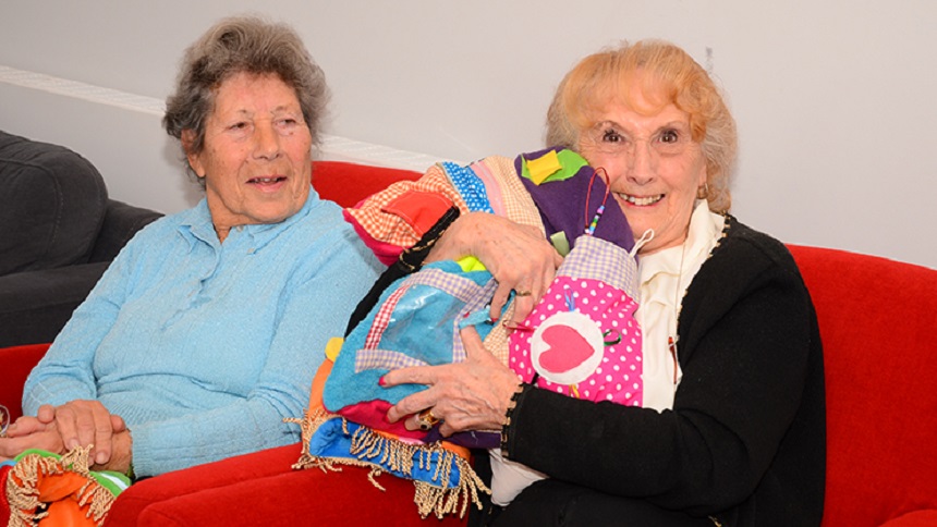 Two women holding fiddle products