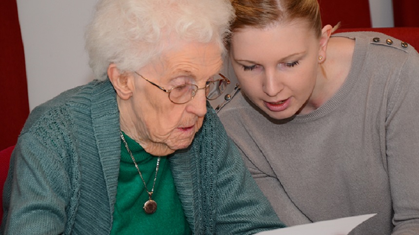 A woman reading with an older woman