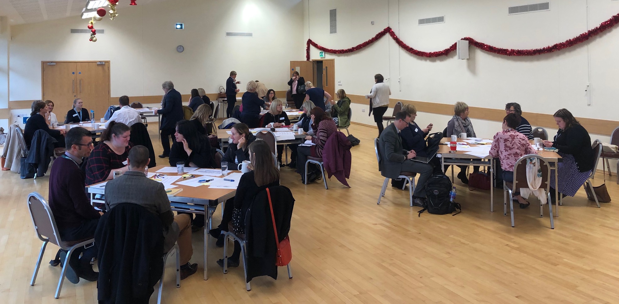 Photo, courtesty of NHS North Norfolk CCG, shows people sitting at tables at an engagement event.