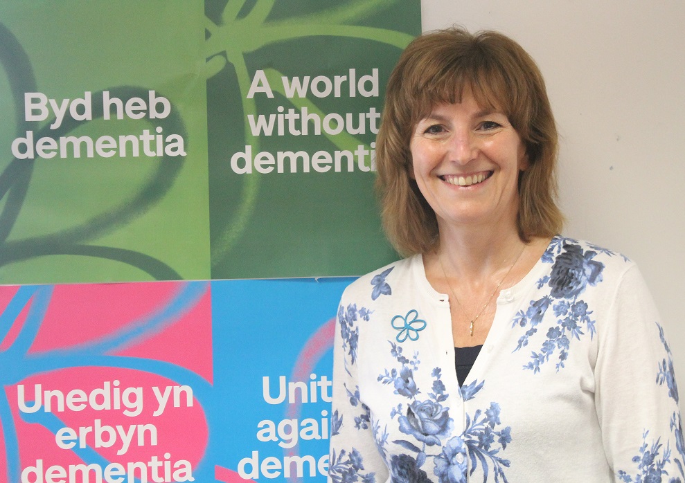 Sue Phelps standing in front of 'A world without dementia' posters