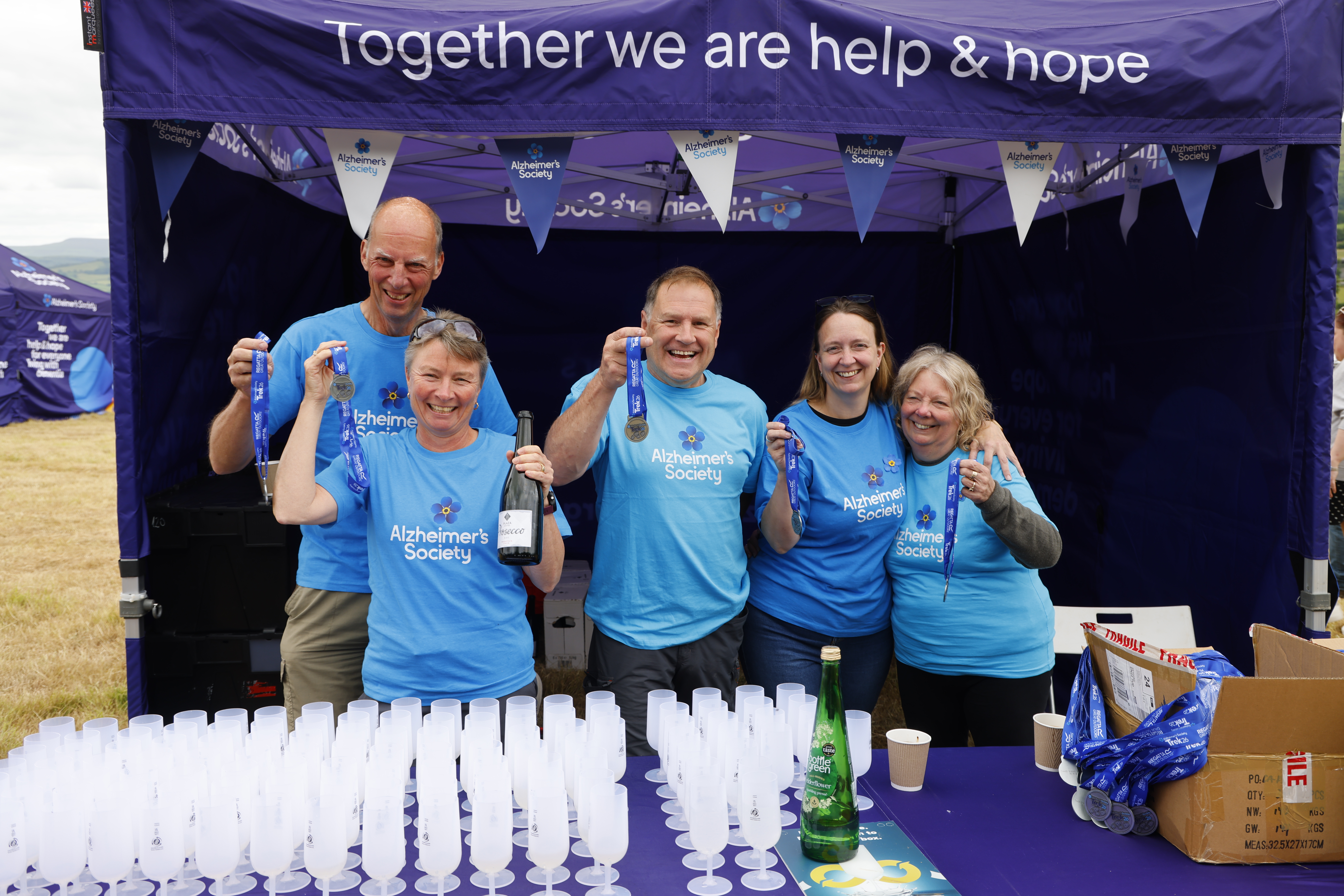 a group of volunteers at an event, holding medals
