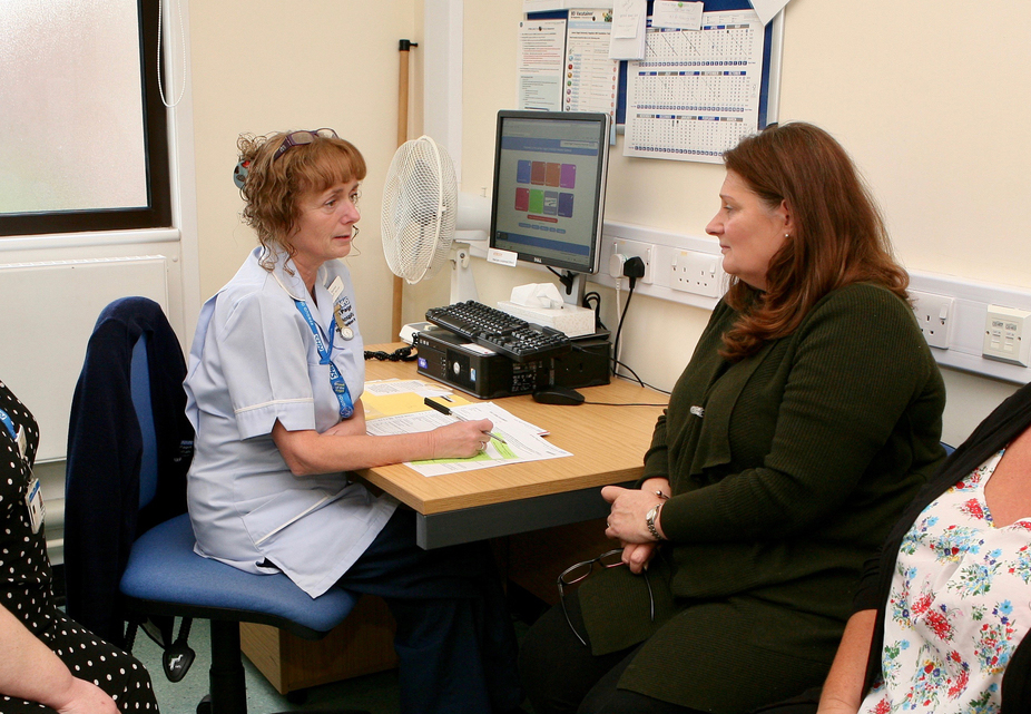 A woman and nurse sitting in an office