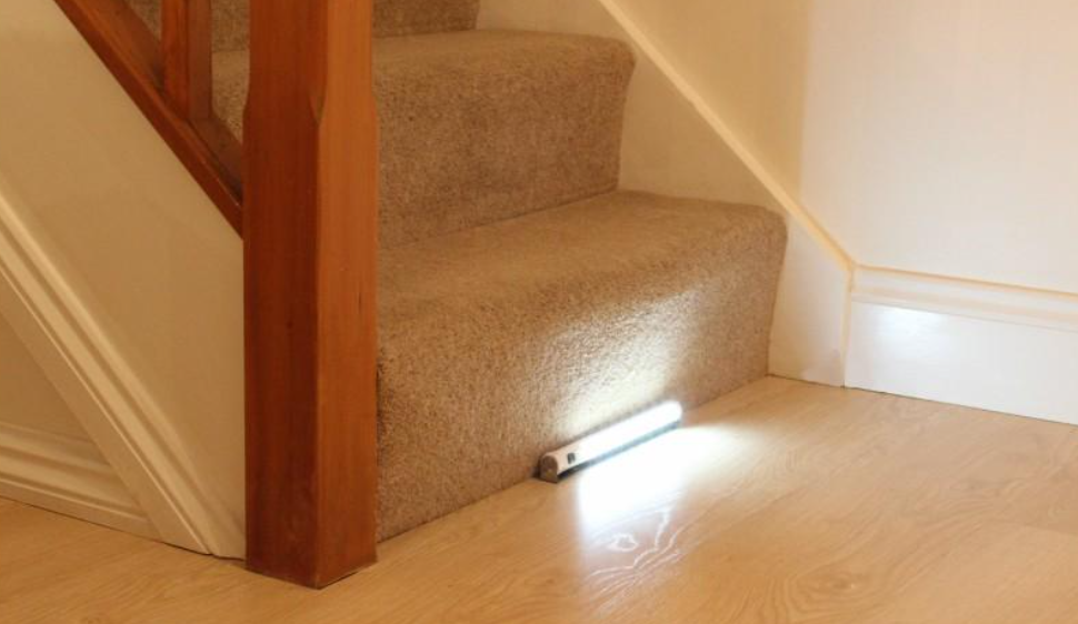 A small tubular light at the bottom of a  flight of stairs