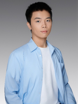 Portrait of a young male PhD student in a blue shirt and white t-shirt.