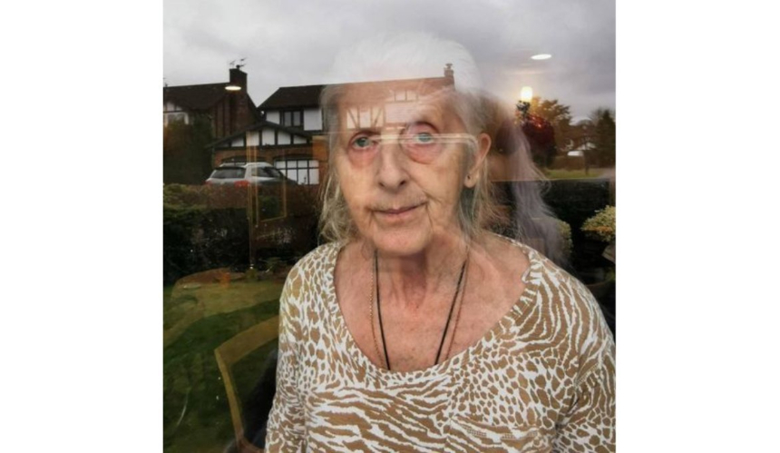 Martina's mum, Jenny, standing at a window of the care home
