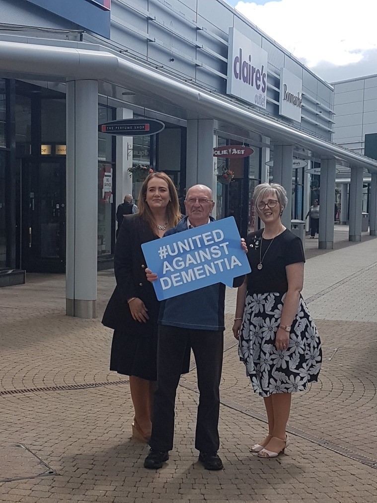 People holding up a United Against Dementia sign at Junction shopping centre