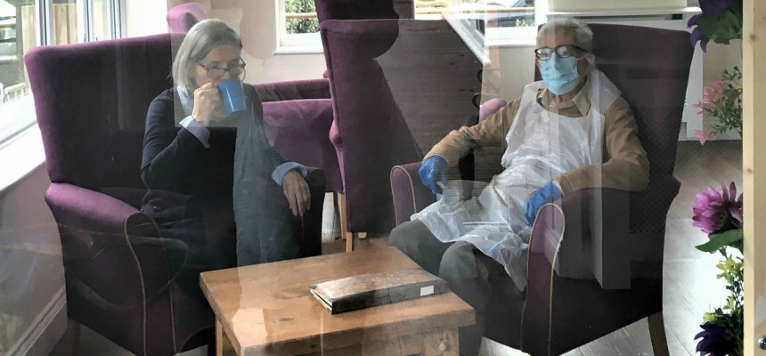 Tony sitting beside his wife, Sheila, wearing PPE