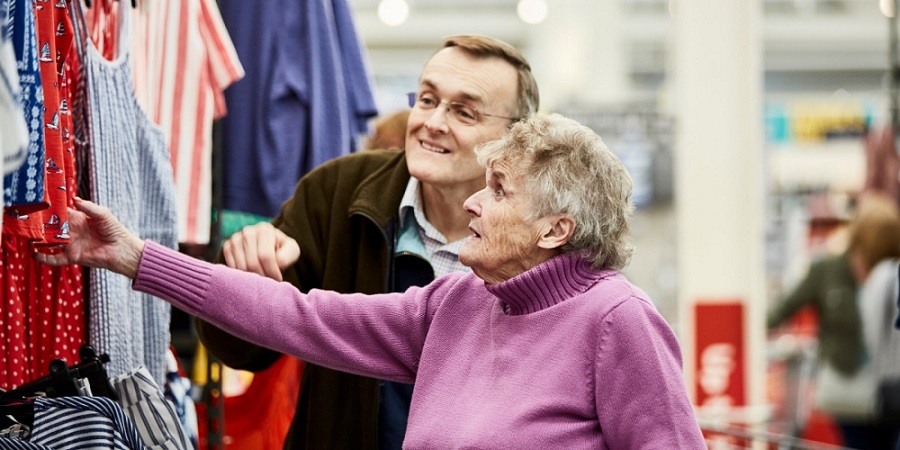 Two people look at clothes in a shop