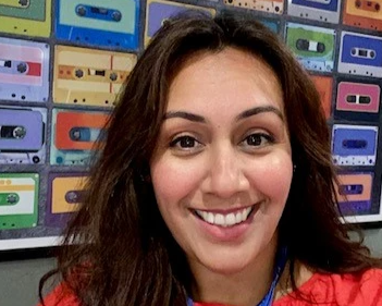 A selfie of a smiling woman with long brown hair