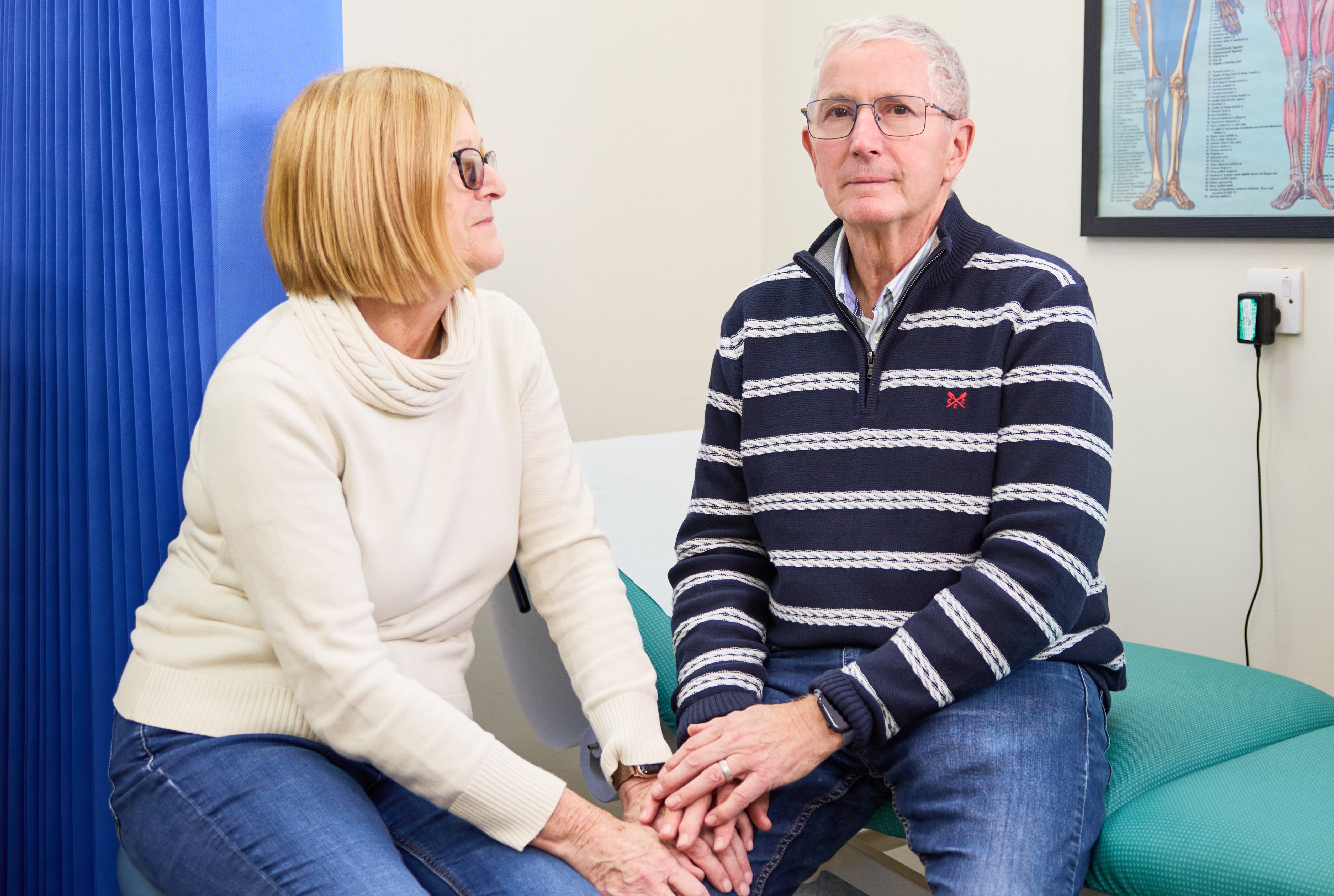 a husband and wife seated at a doctor surgery appointment