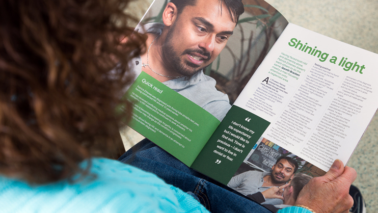 Someone reading Living with dementia magazine
