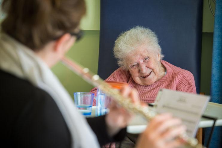 Alis Eaton plays the flute to hospital patient Ivy