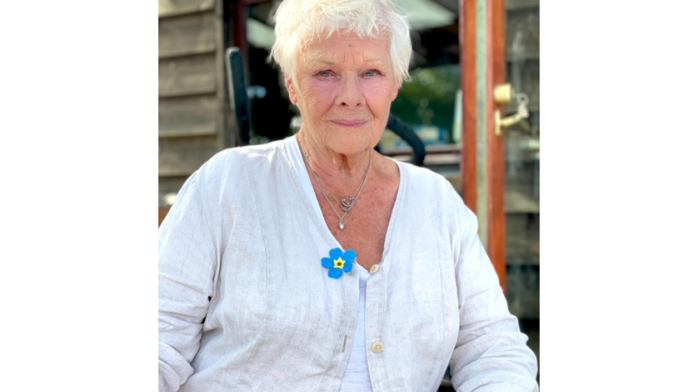 Portrait of Dame Judi Dench wearing a forget-me-not badge