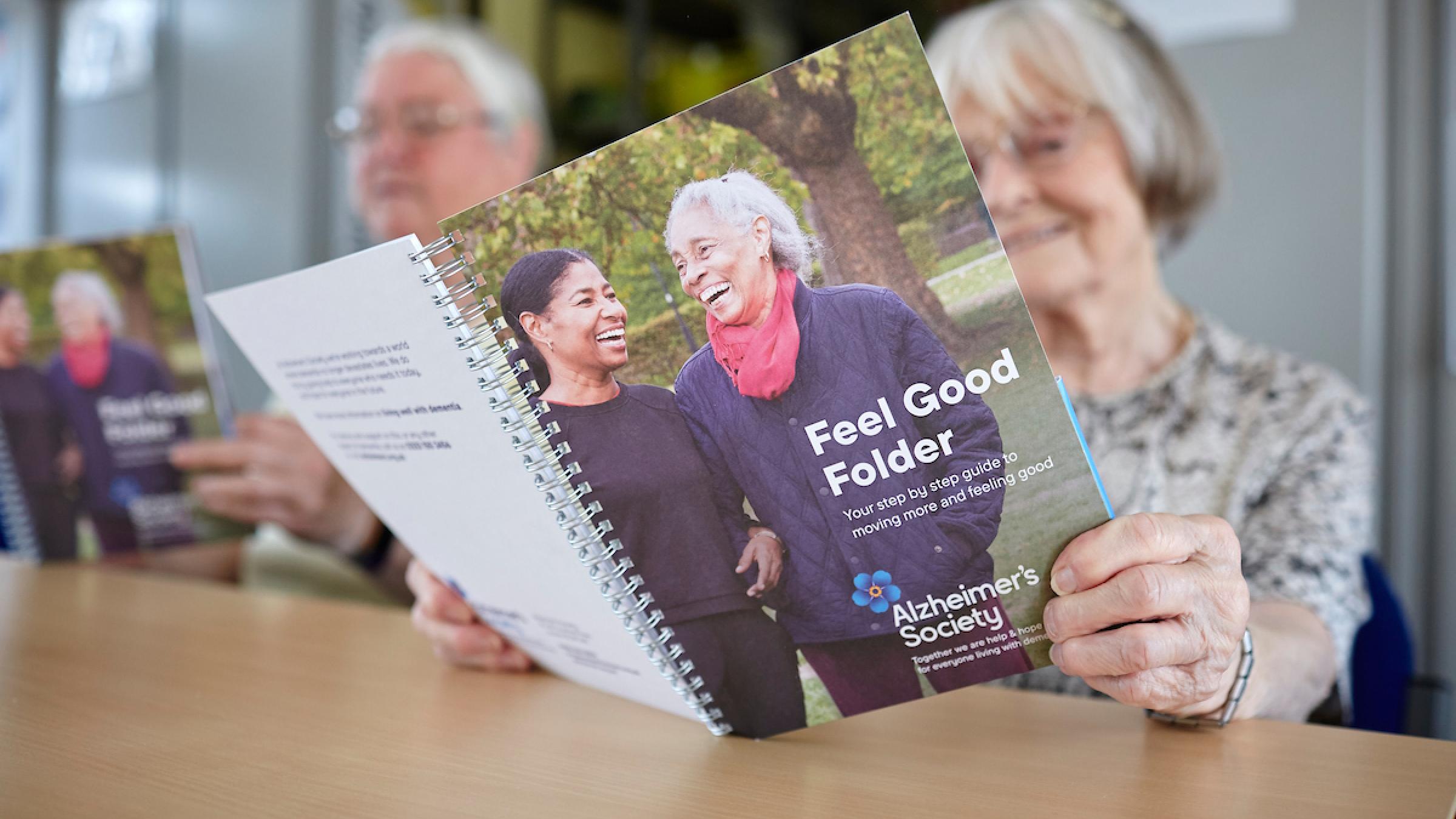 Two people reading the Feel Good Folder 
