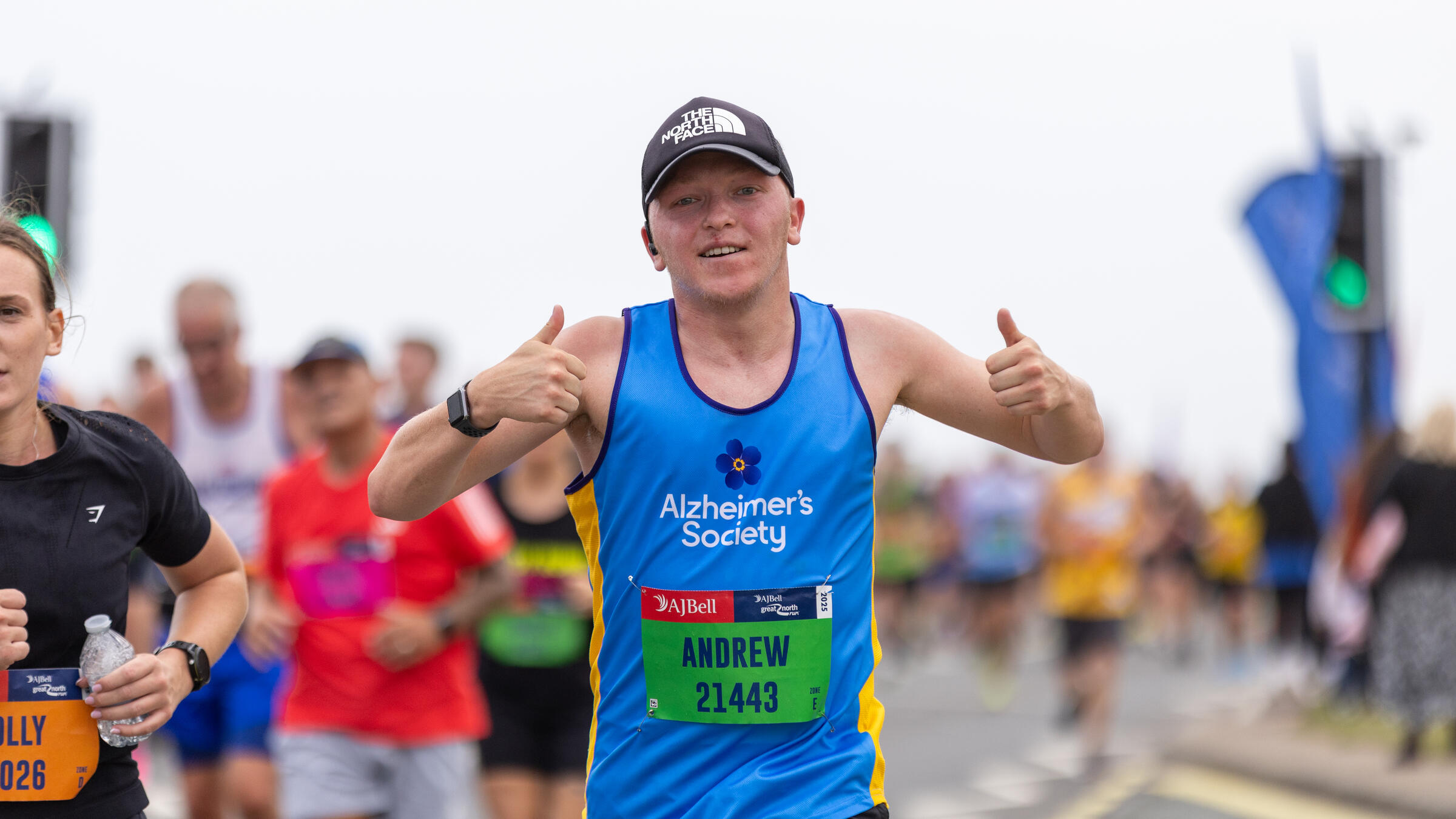A man in an Alzheimer's Society top with two thumbs raised
