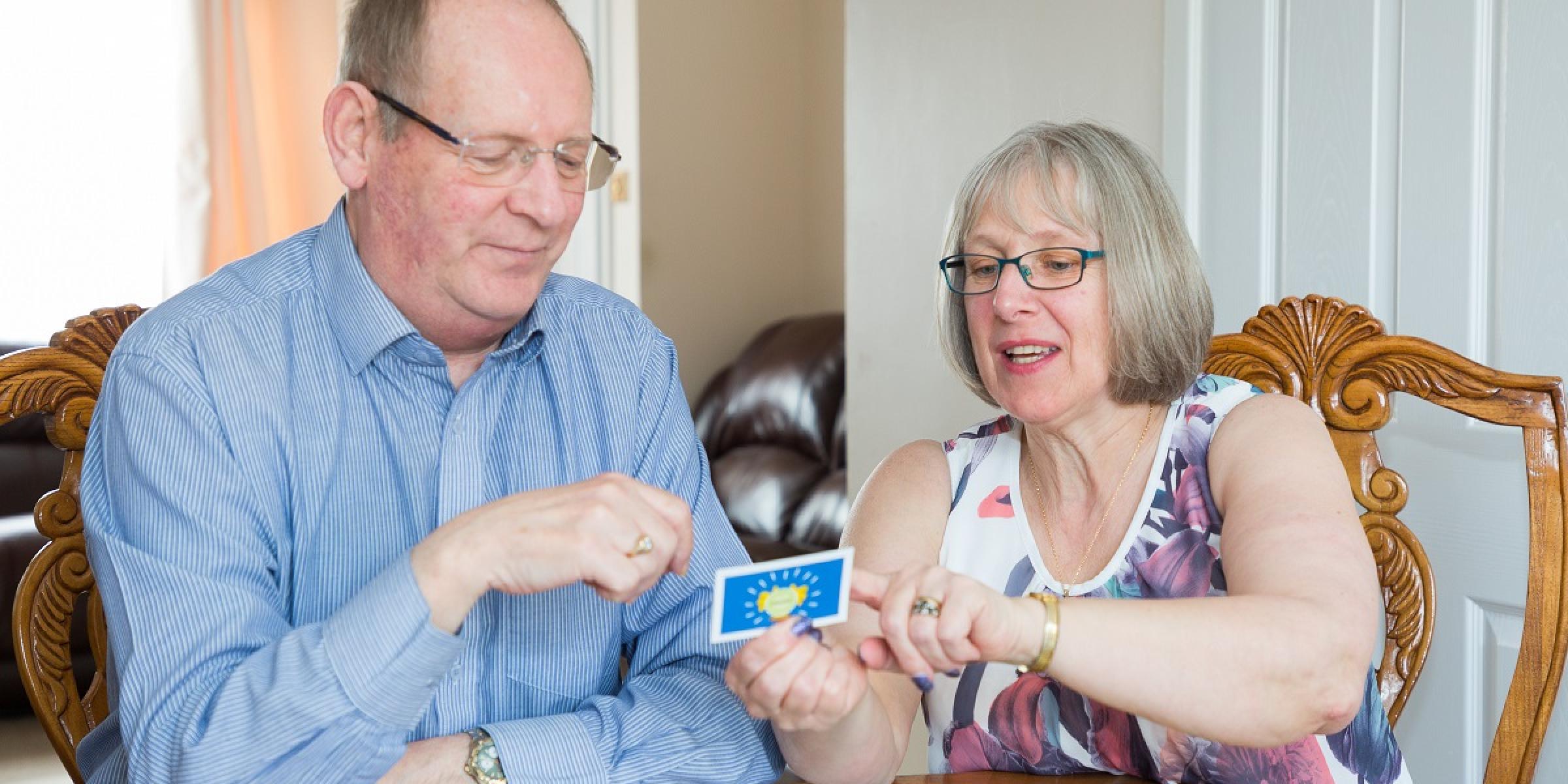 A person with dementia and their primary carer playing Monopoly