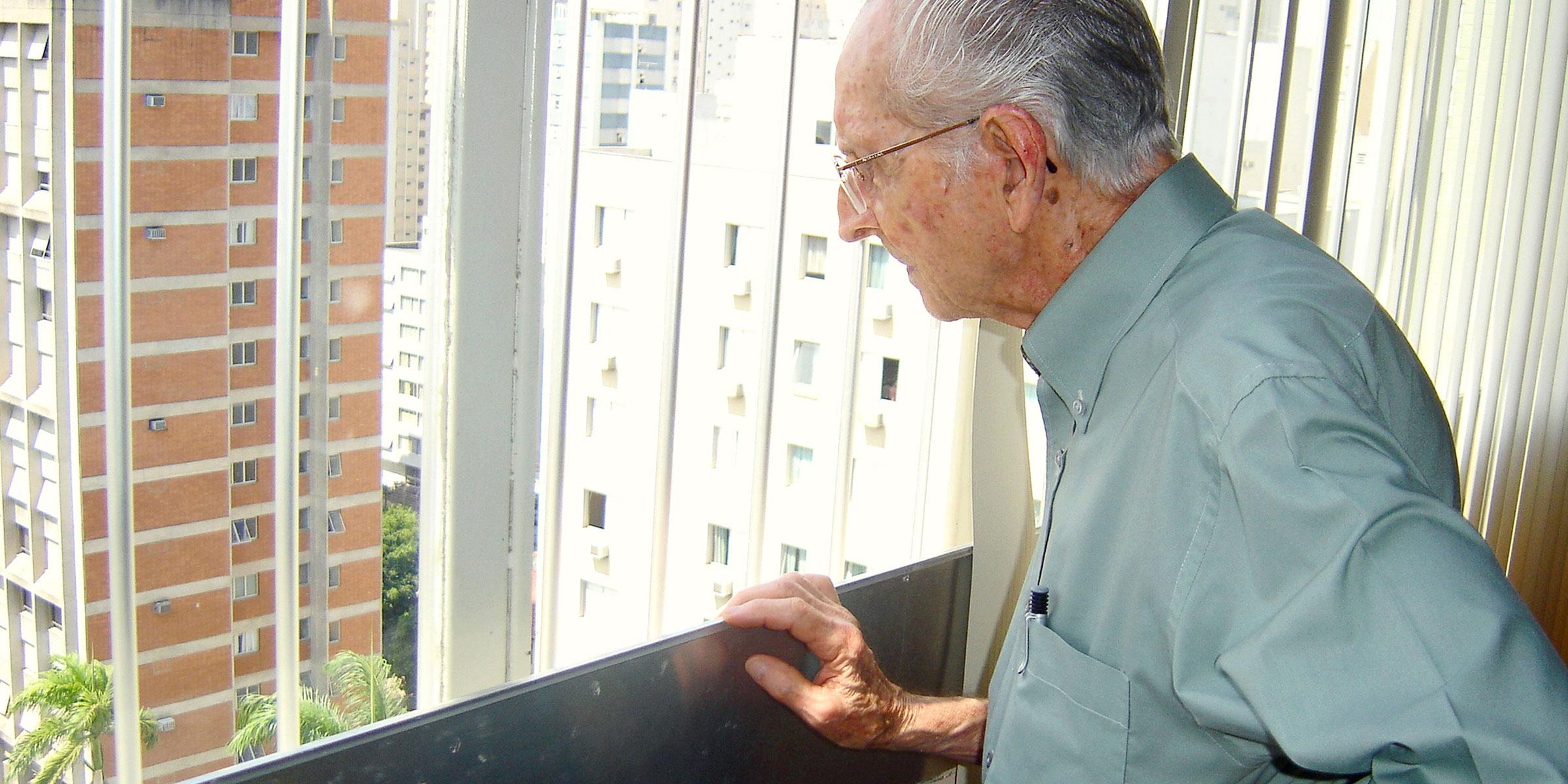 Older man looking out a window