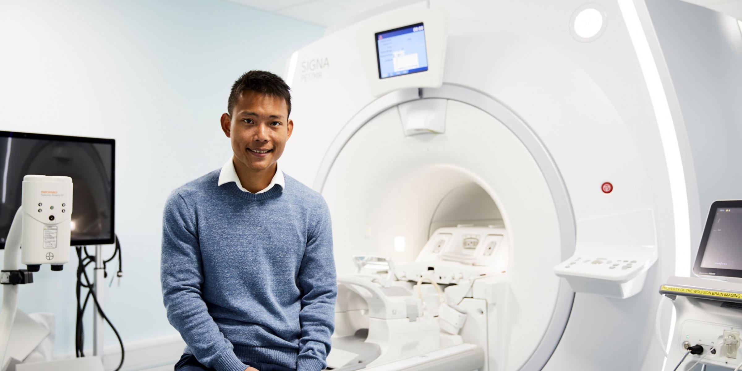 Dr Elijah Mak with an MRI scanner