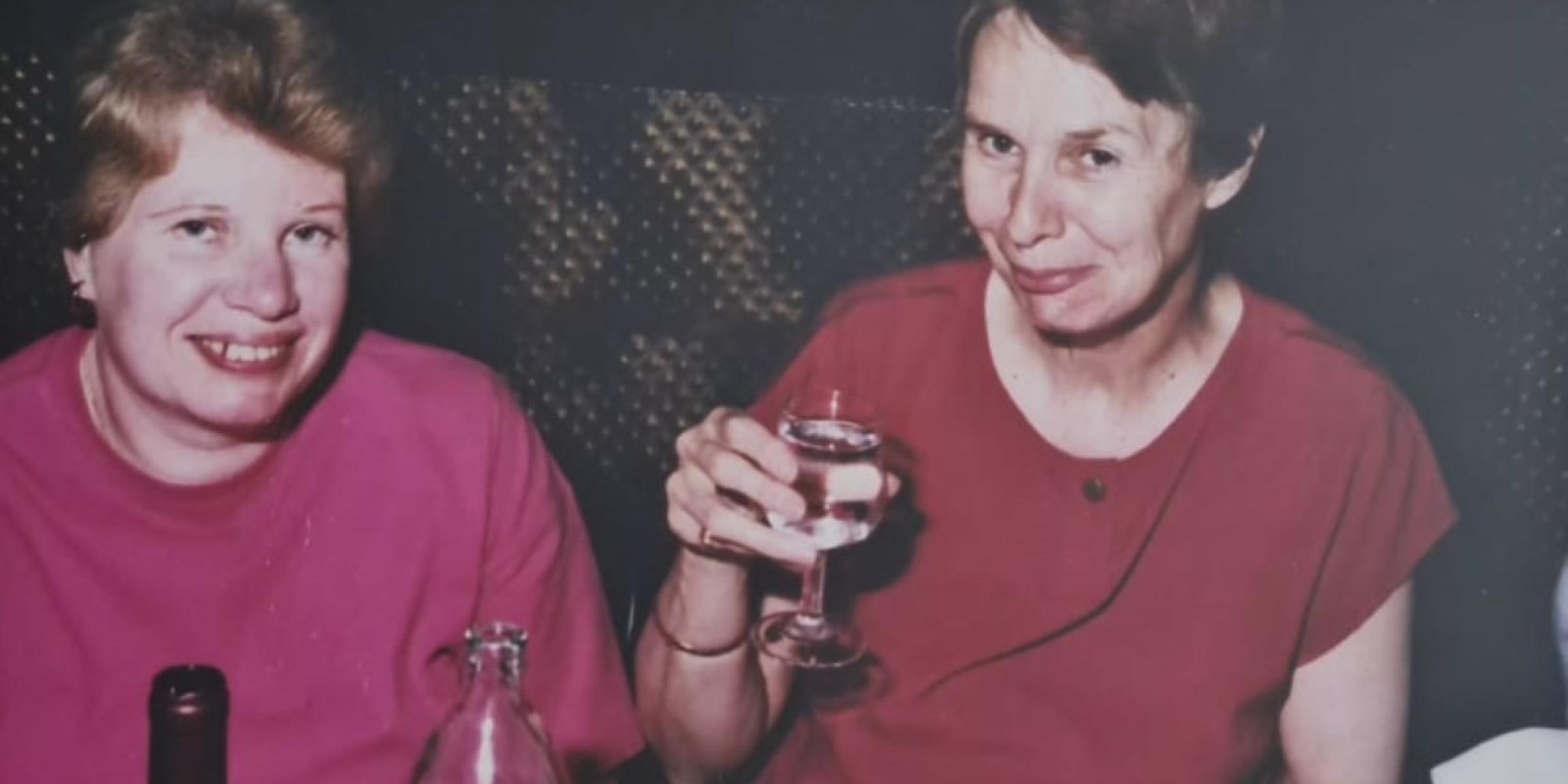 A picture of a photograph with Brenda and Jo smiling, holding a glass of wine