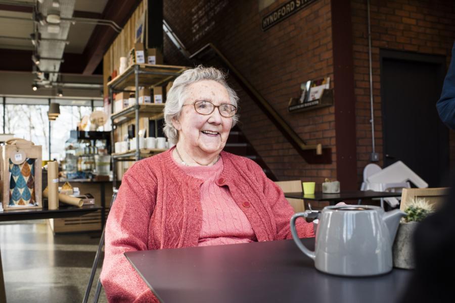 A woman with dementia sitting down in a cafe