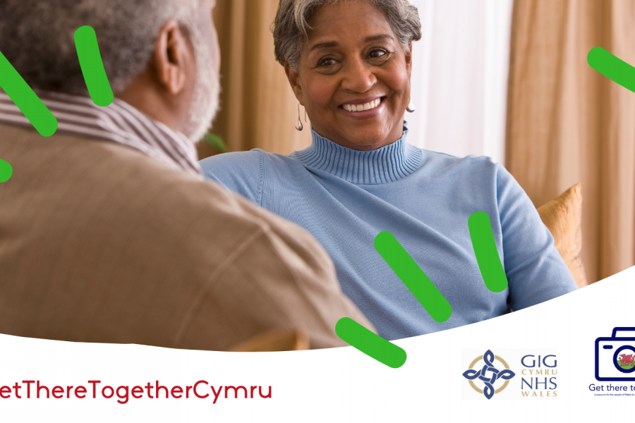 A woman smiling in conversation with a man