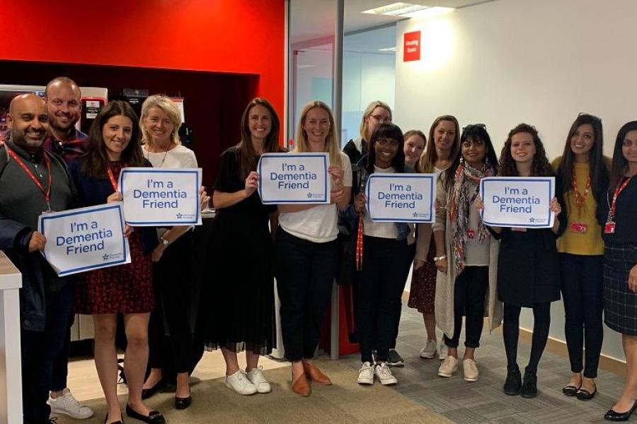 A group of Santander UK employees holding up signs that read 'I'm a Dementia Friend'
