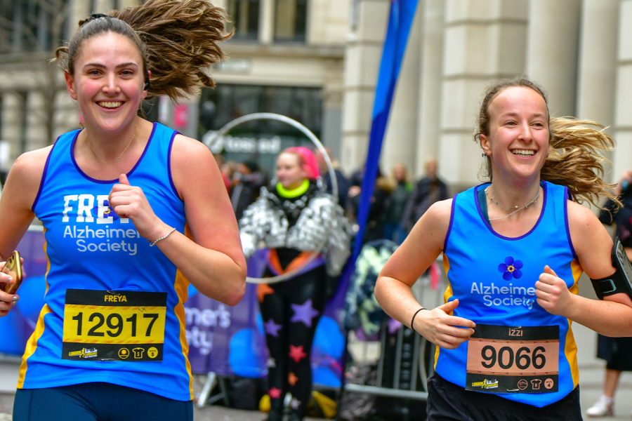 Two female runners smiling 